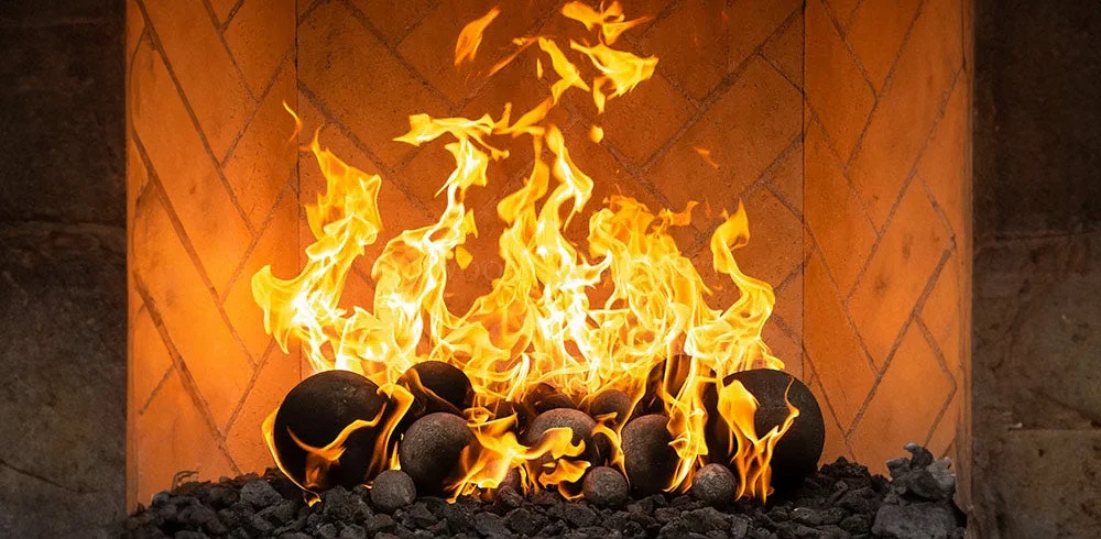 close up of ceramic fire balls in a fireplace with an open flame