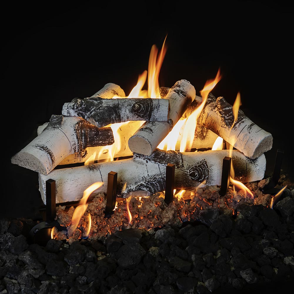 Vented gas log set with white-gray logs and bright flames over black fire rock bed
