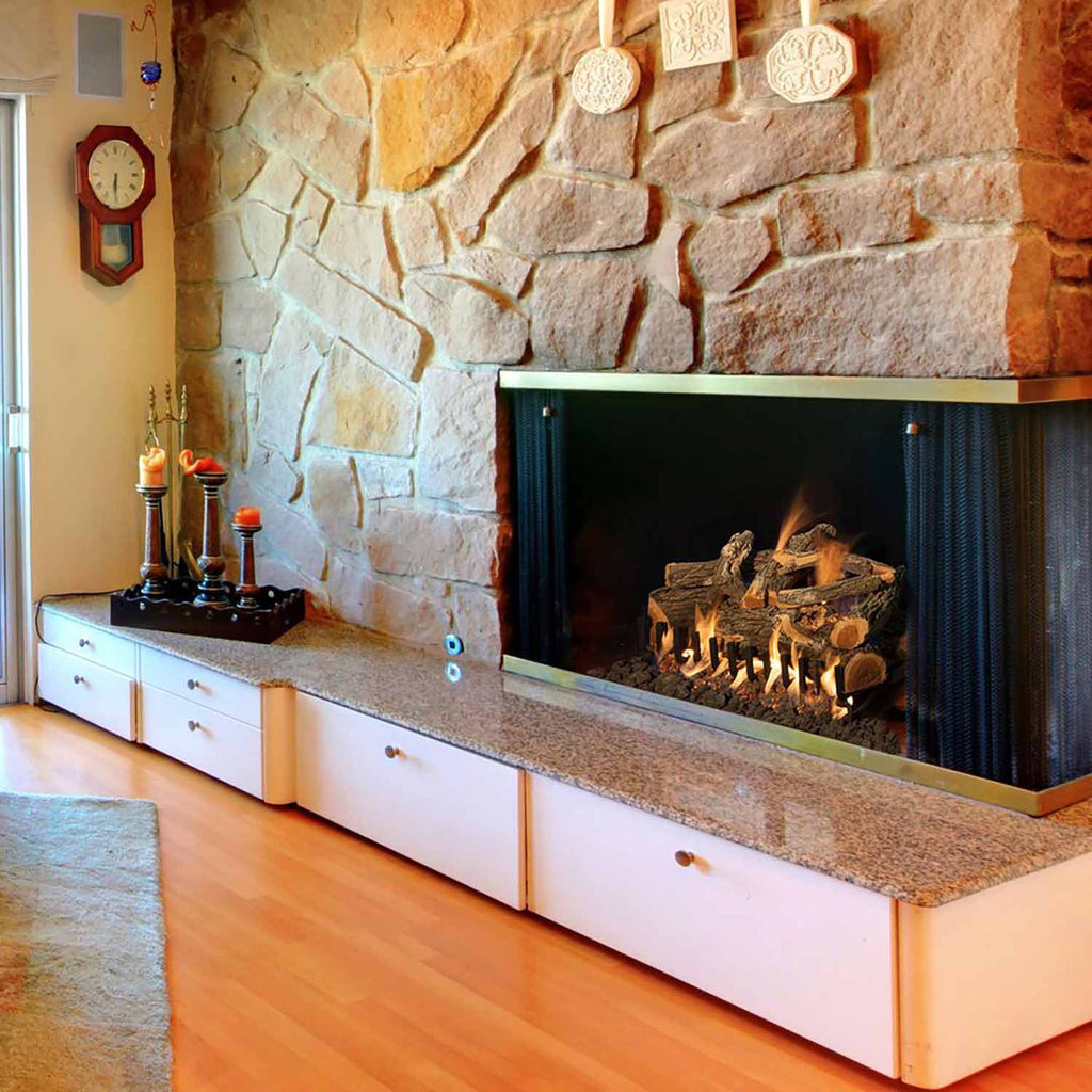 Vented gas log set with weathered oak logs burning in a stone fireplace