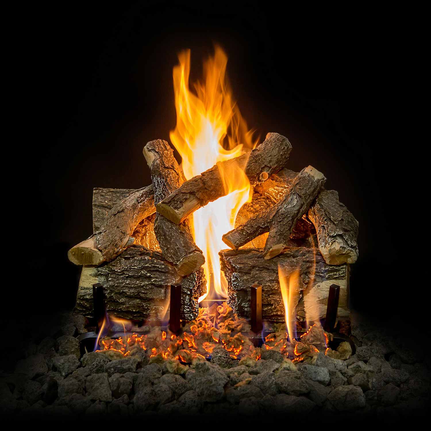 Vented gas log set with charred logs, tall flames, and glowing embers over lava rock