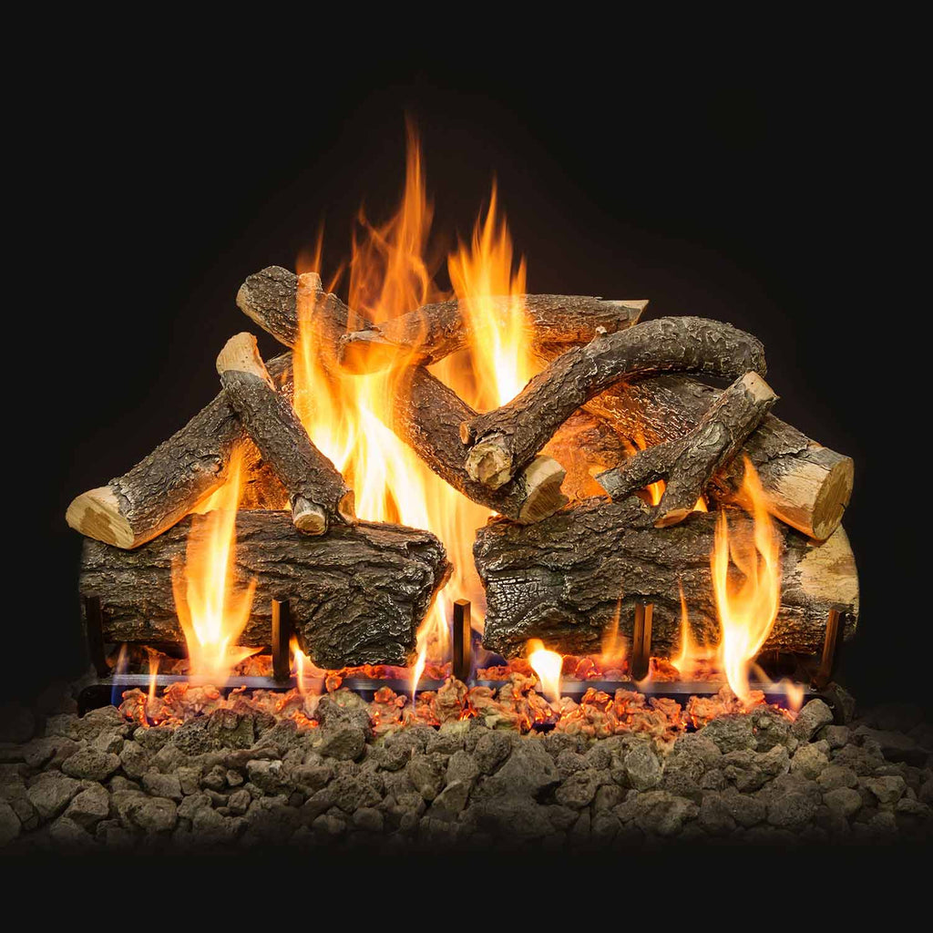 Stacked charred gas logs with multiple flames rising over glowing embers