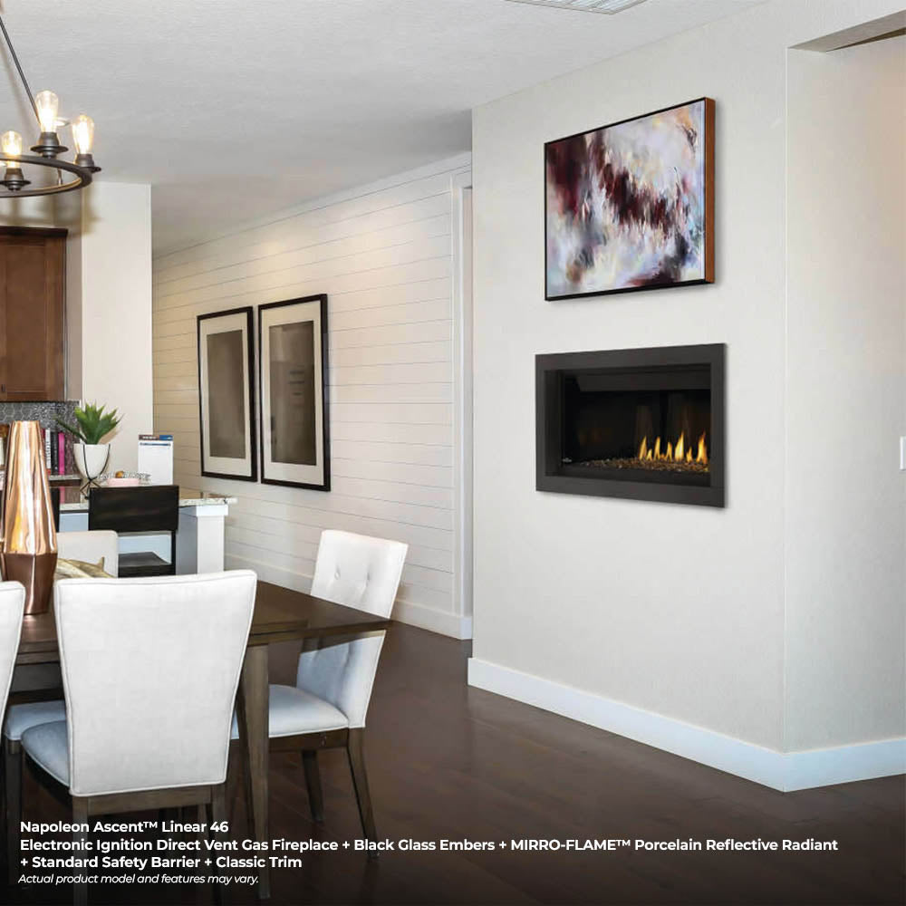Black linear direct vent gas fireplace set into wall niche with glowing flames