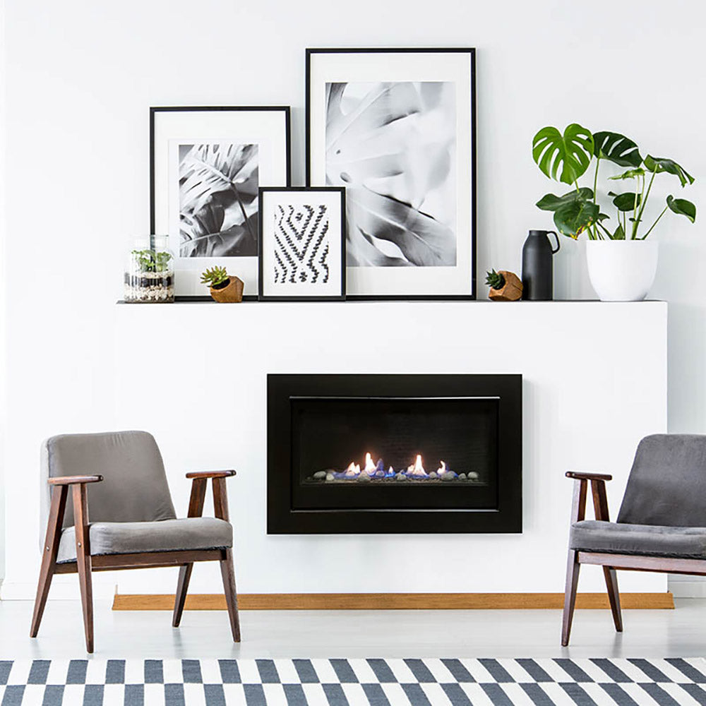 Black inset gas fireplace with flame burning behind a rectangular viewing glass