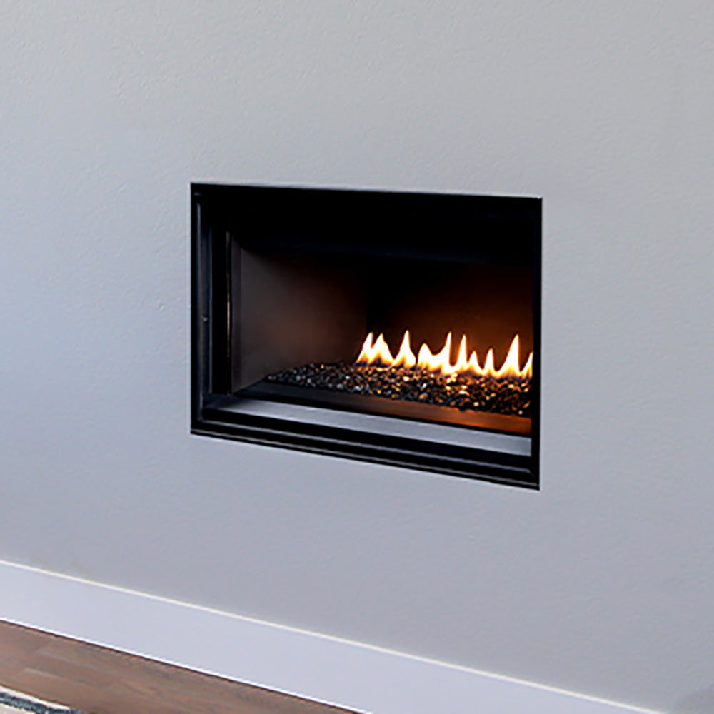 Direct vent gas fireplace with black trim and burning flames over crushed glass
