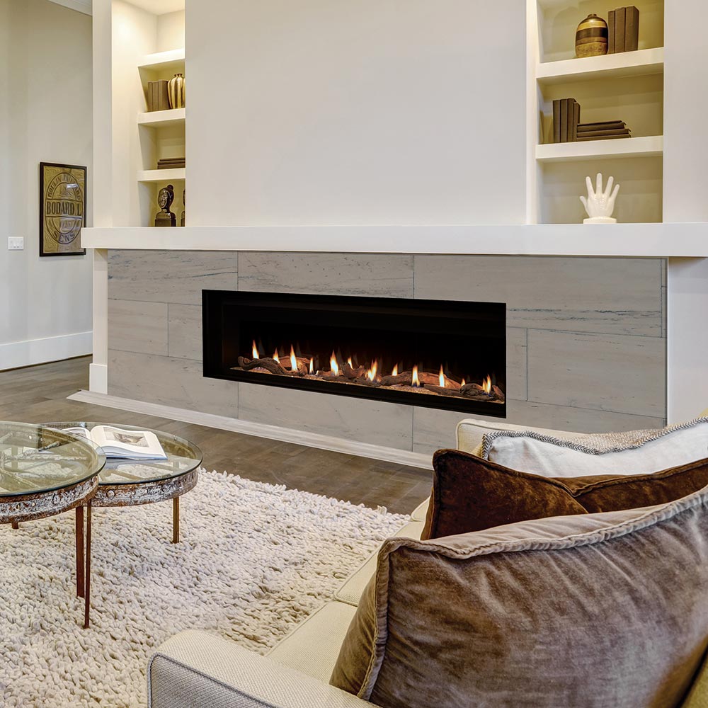 Direct vent gas fireplace insert with flames and crushed glass media in a stone surround