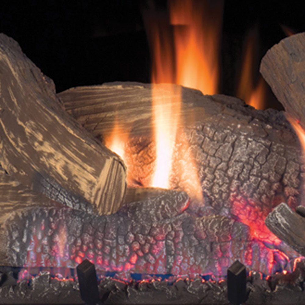 Close-up of burning gas fireplace logs with orange flames and red embers