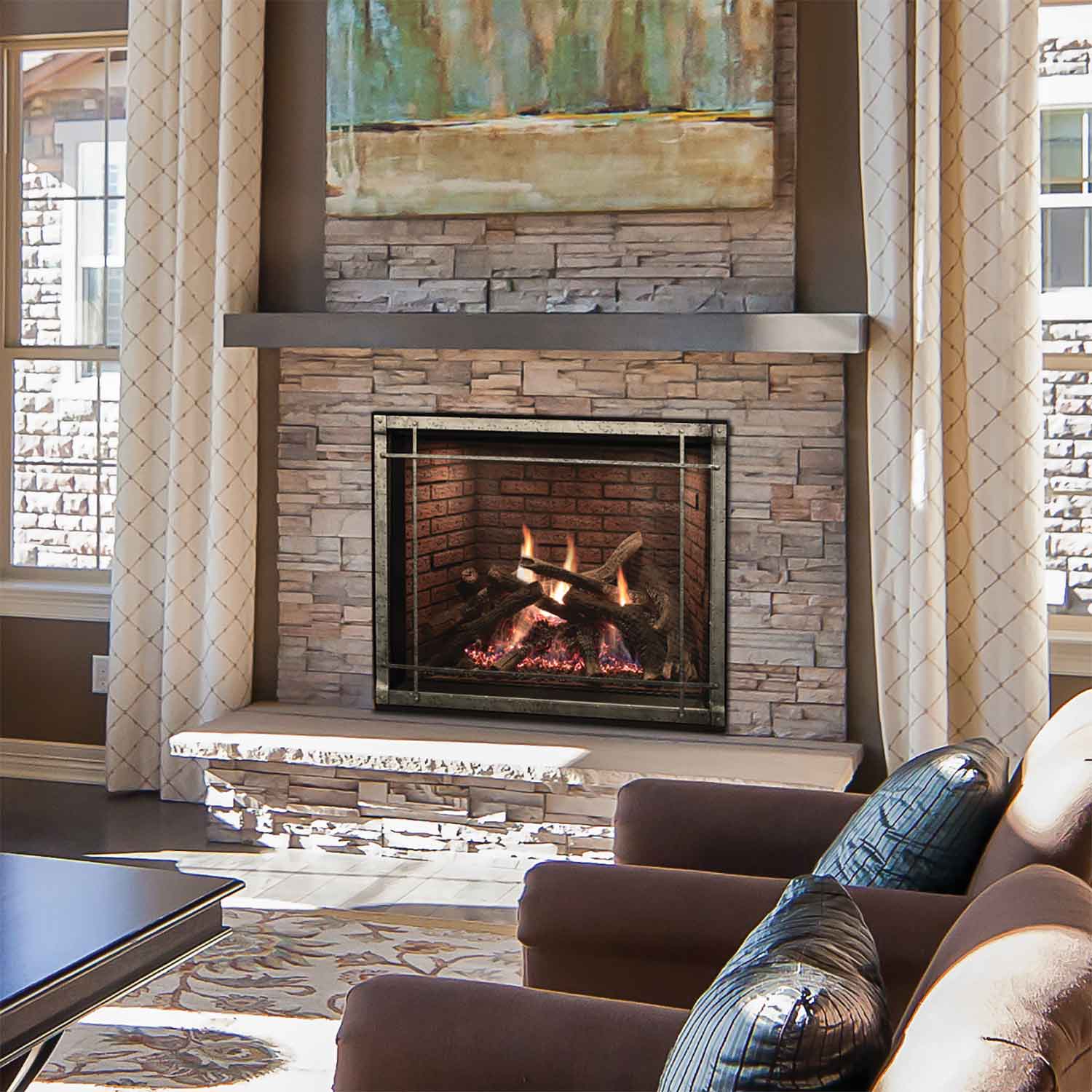 Stone-surround direct-vent fireplace with black firebox and burning logs in a living room