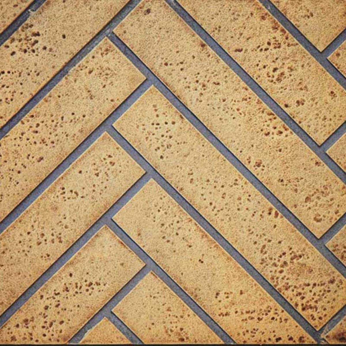 Sandstone decorative fireplace panel with herringbone pattern and dark trim
