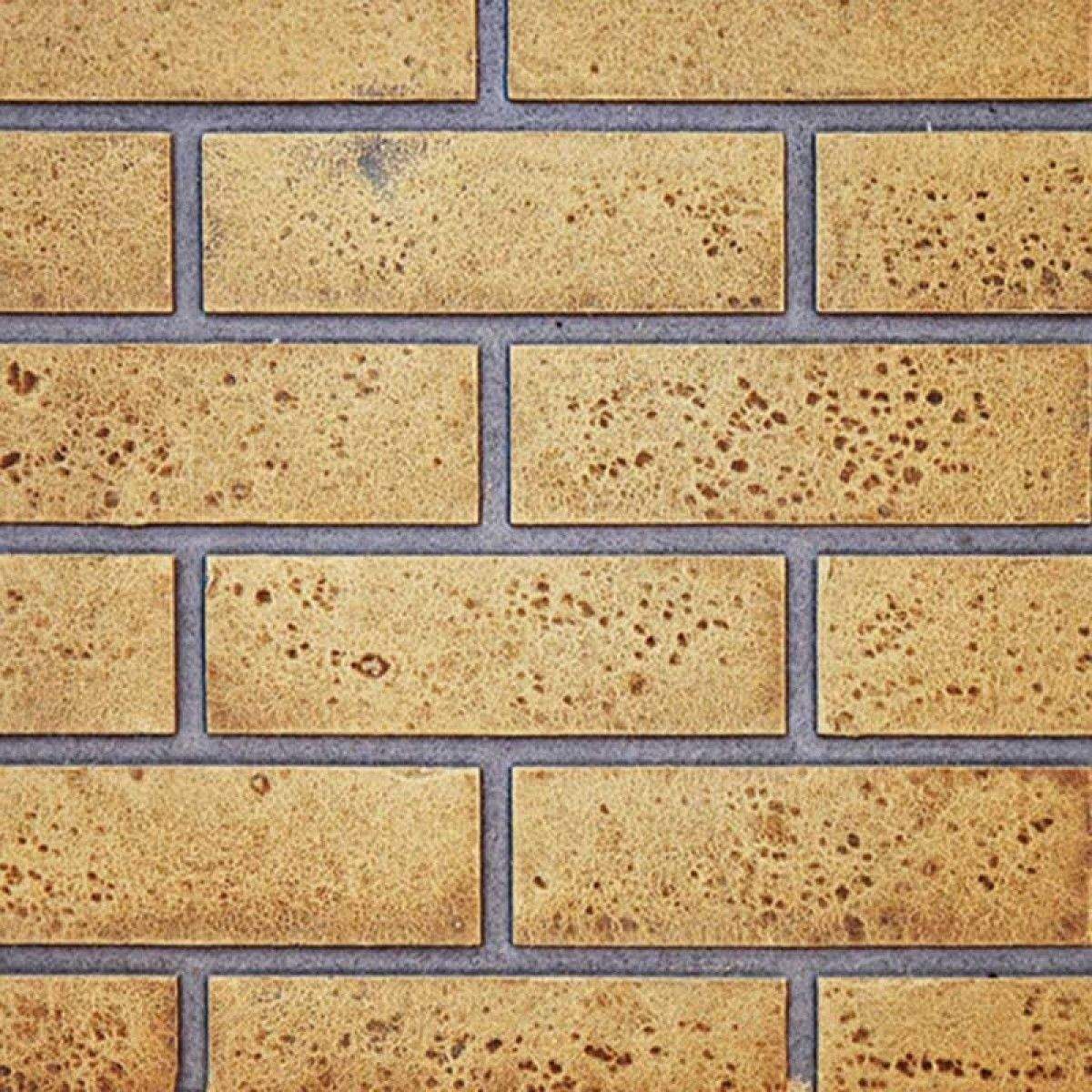 Sandstone decorative brick panel with tan speckled rectangles and dark gray grout lines