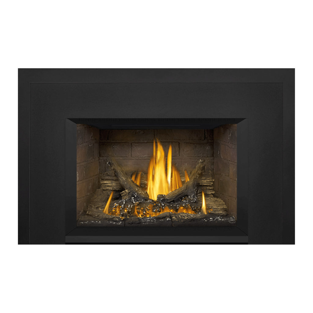 Direct vent gas fireplace insert with dark surround and brick back, flames in log bed.