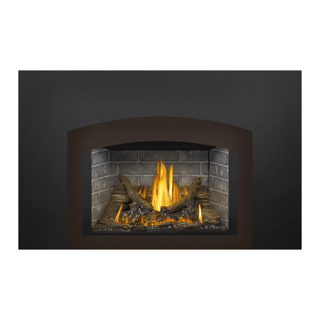 Direct vent gas fireplace insert with dark surround, stone back, and lit logs with upward flames