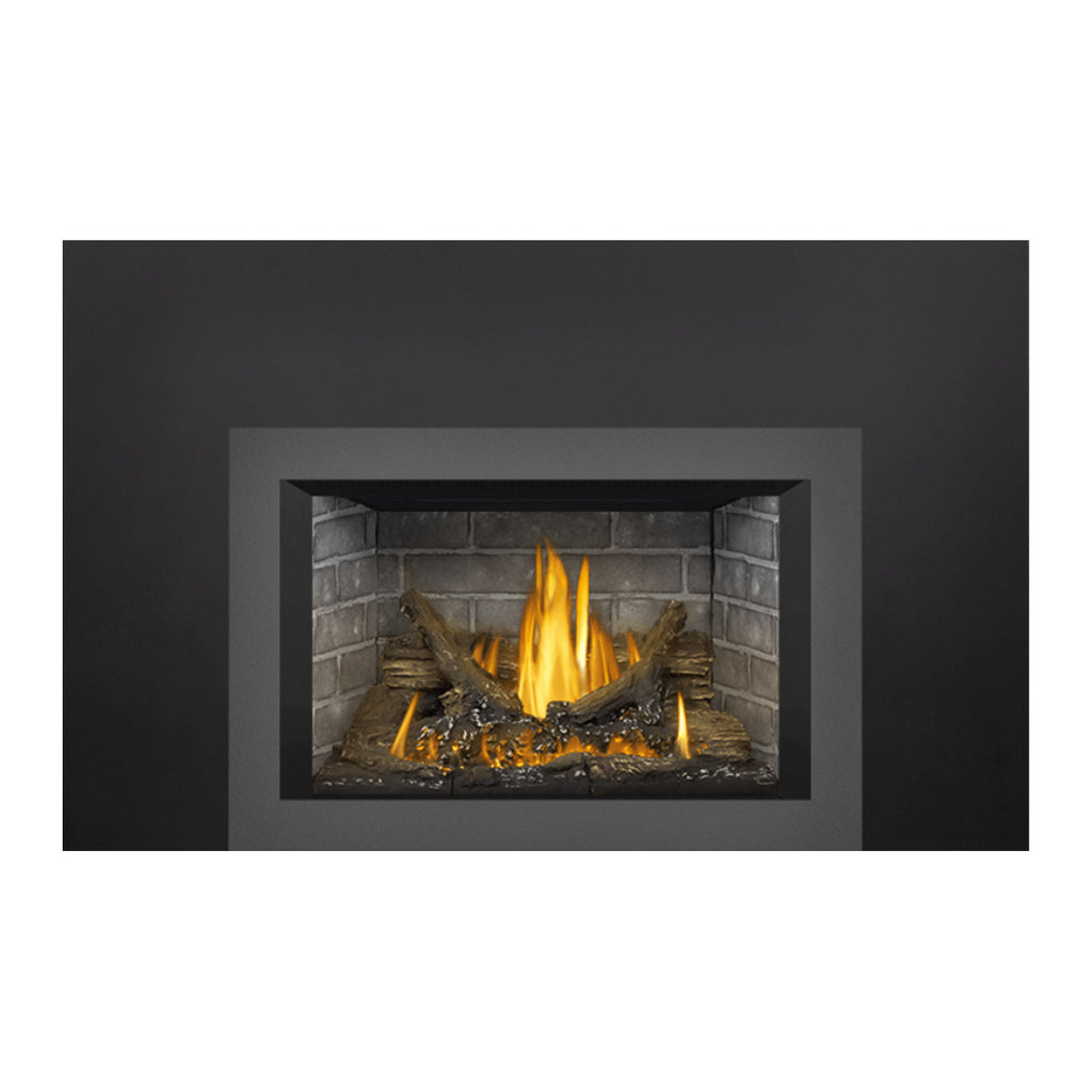 Direct vent gas fireplace insert with dark viewing frame, brick interior, burning logs and fire