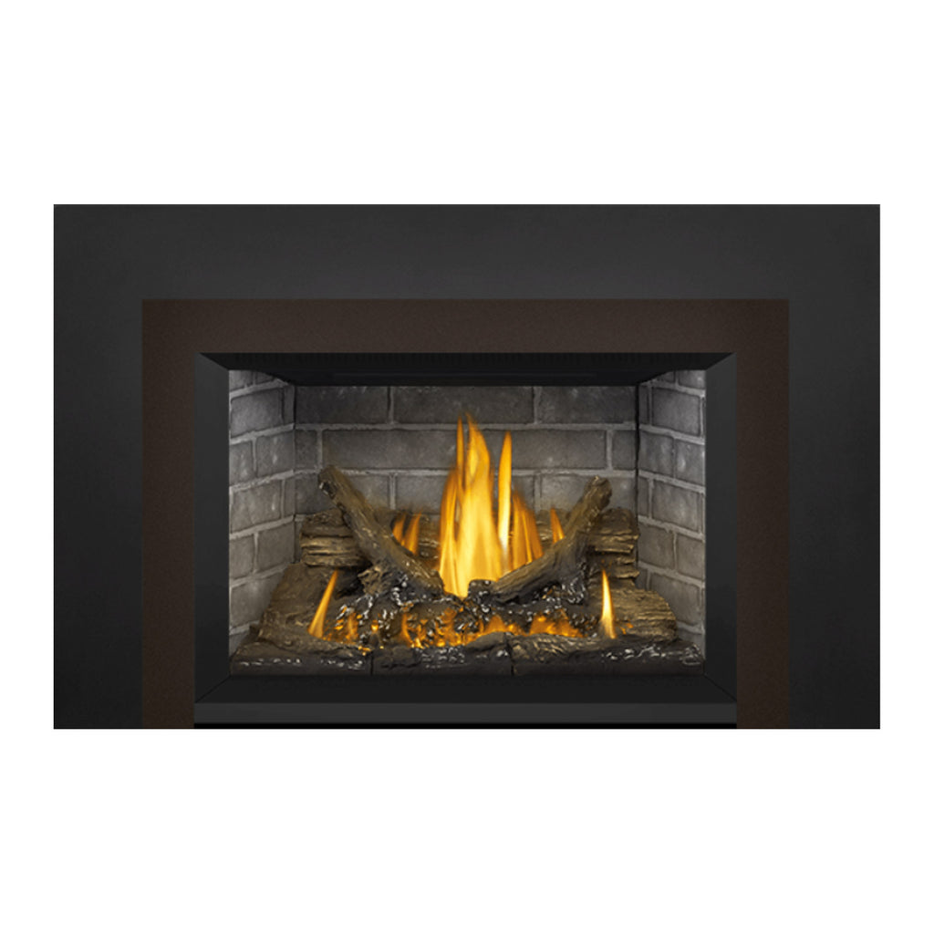 Direct vent gas fireplace insert showing tall flames above glowing logs in brick firebox