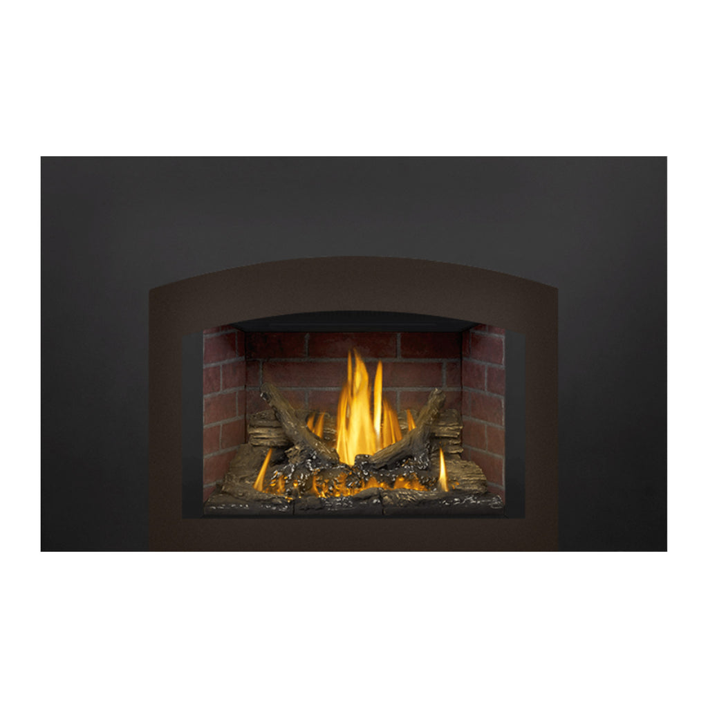 Direct vent gas fireplace insert with burning flames over logs and red brick interior, dark surround