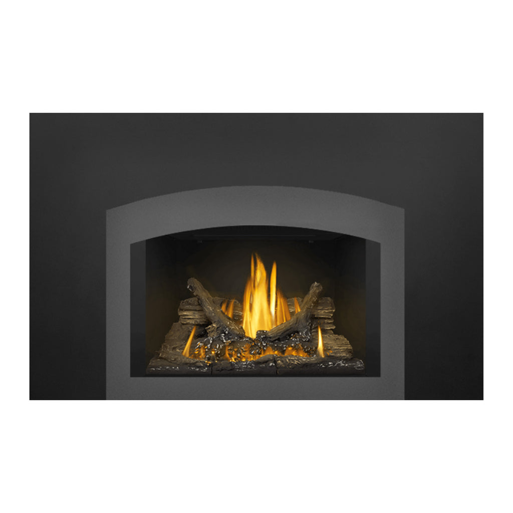 Direct vent gas fireplace insert showing glowing logs with tall yellow flames in dark firebox