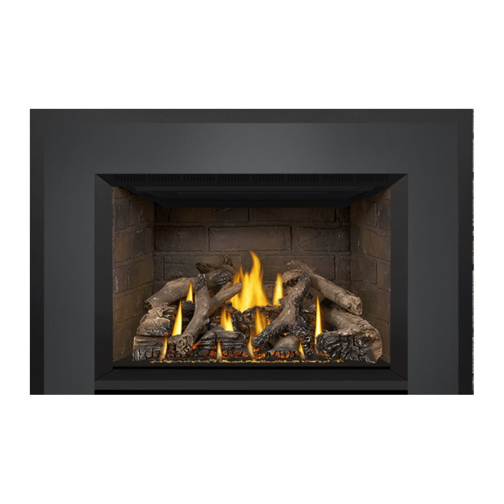 Gas fireplace insert view with stone firebox and burning logs under a black hood.