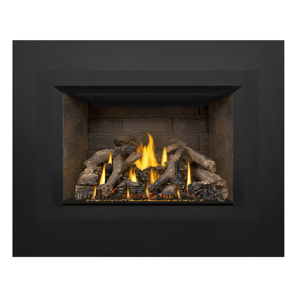 Direct vent gas fireplace insert with dark trim, stone interior, and flames over logs.