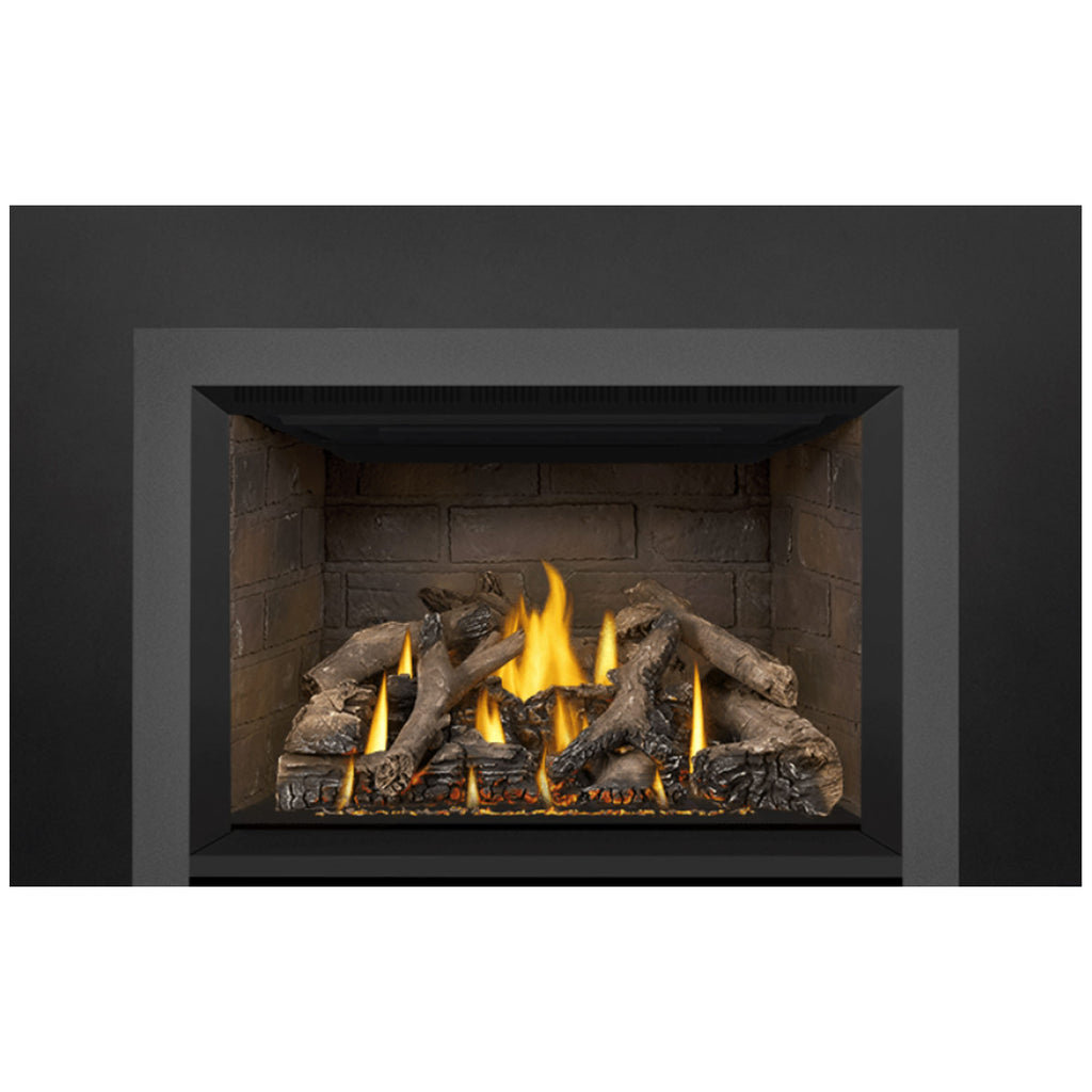 Gas fireplace insert front view with bright flames and dark logs across the firebed