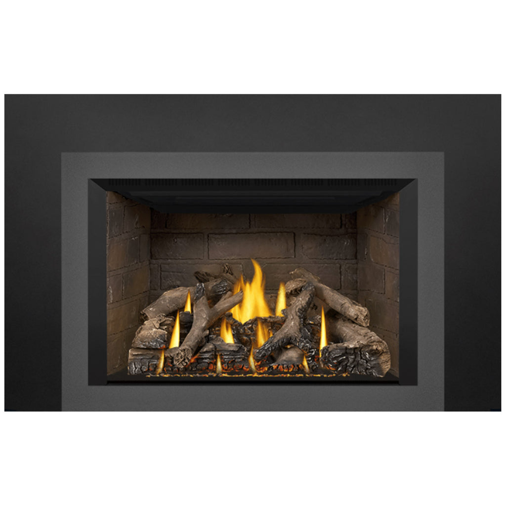 Direct vent gas fireplace insert showing stone firebox wall, flames, and charred logs.