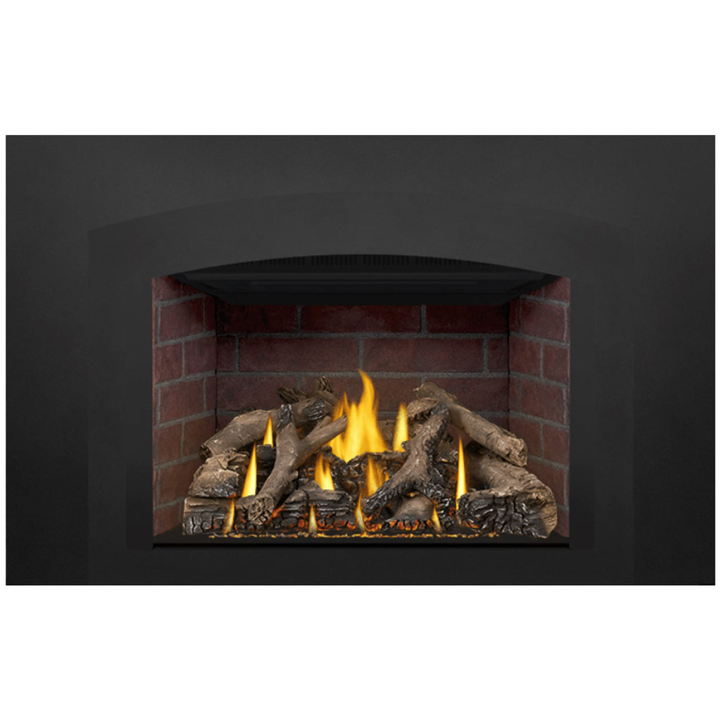 Direct-vent gas fireplace insert with lit logs and yellow-orange flames in a red brick opening