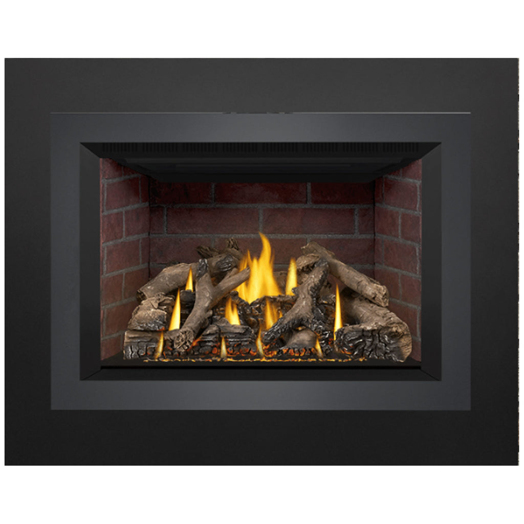Direct-vent gas fireplace insert showing flames over dark logs in a red brick firebox