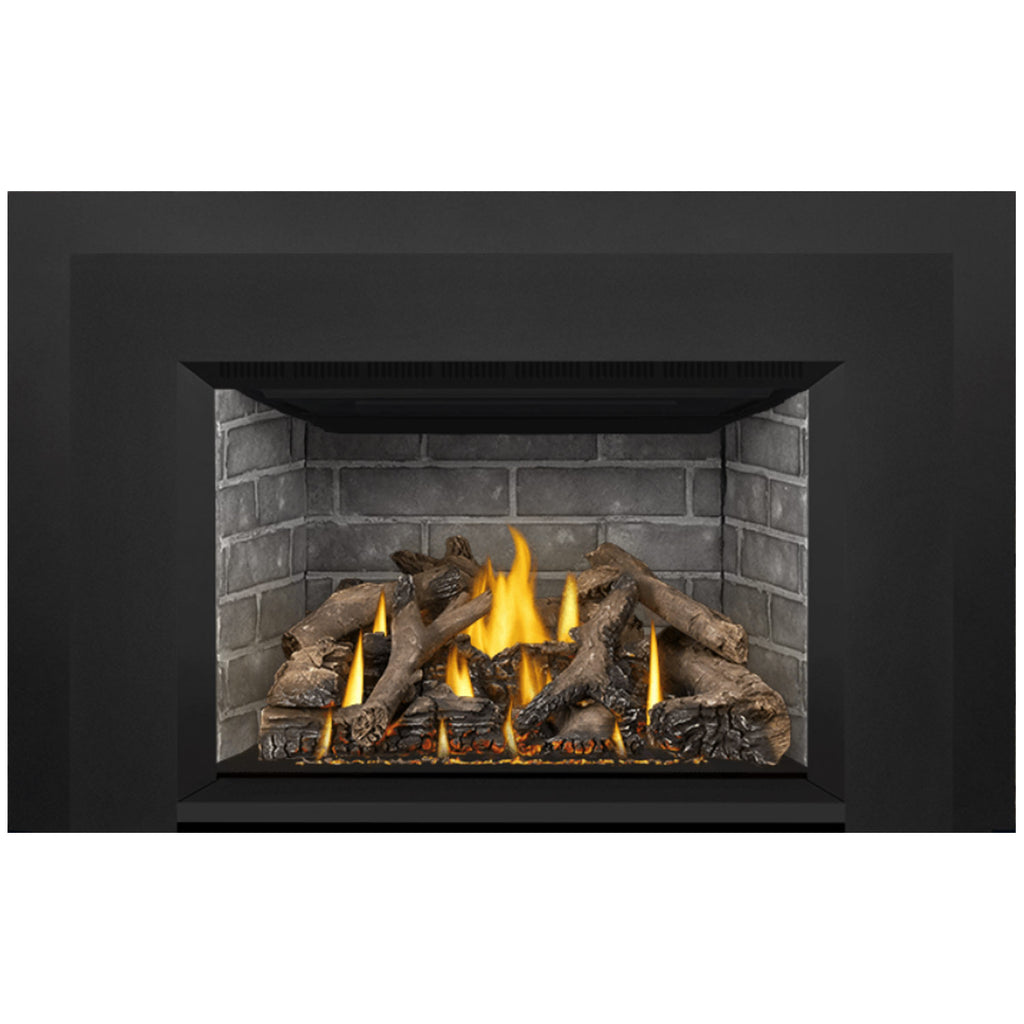 Gas fireplace insert with burning flames, gray stone surround, and dark log set