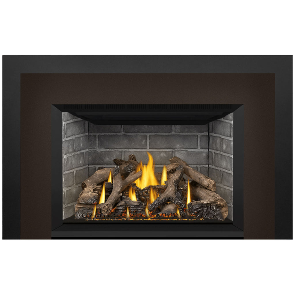 Direct vent gas fireplace insert with dark surround, stone firebox, and burning logs