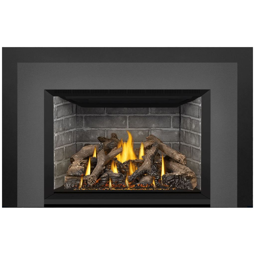 Direct vent gas fireplace insert with dark outer panel and stone firebox; flames on log bed