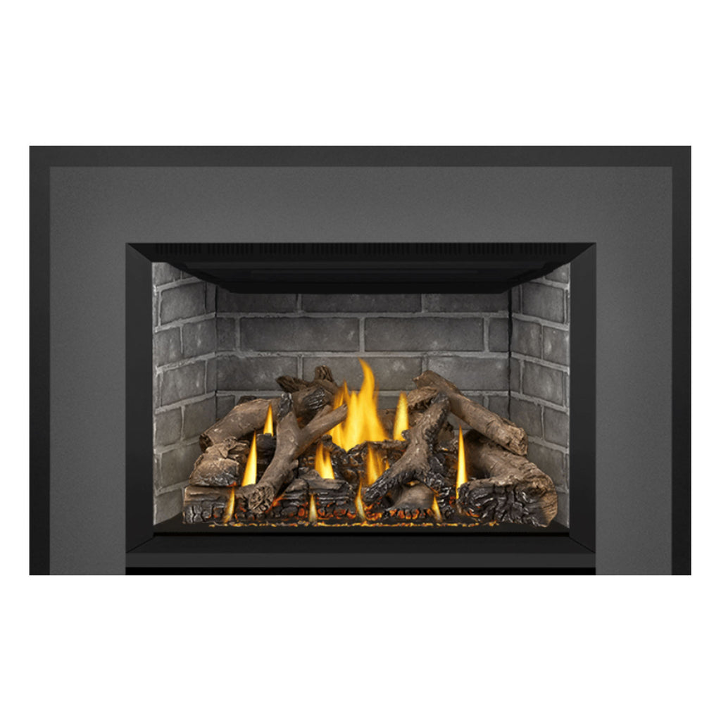 Direct vent gas fireplace insert showing dark frame and stone firebox with flames over logs