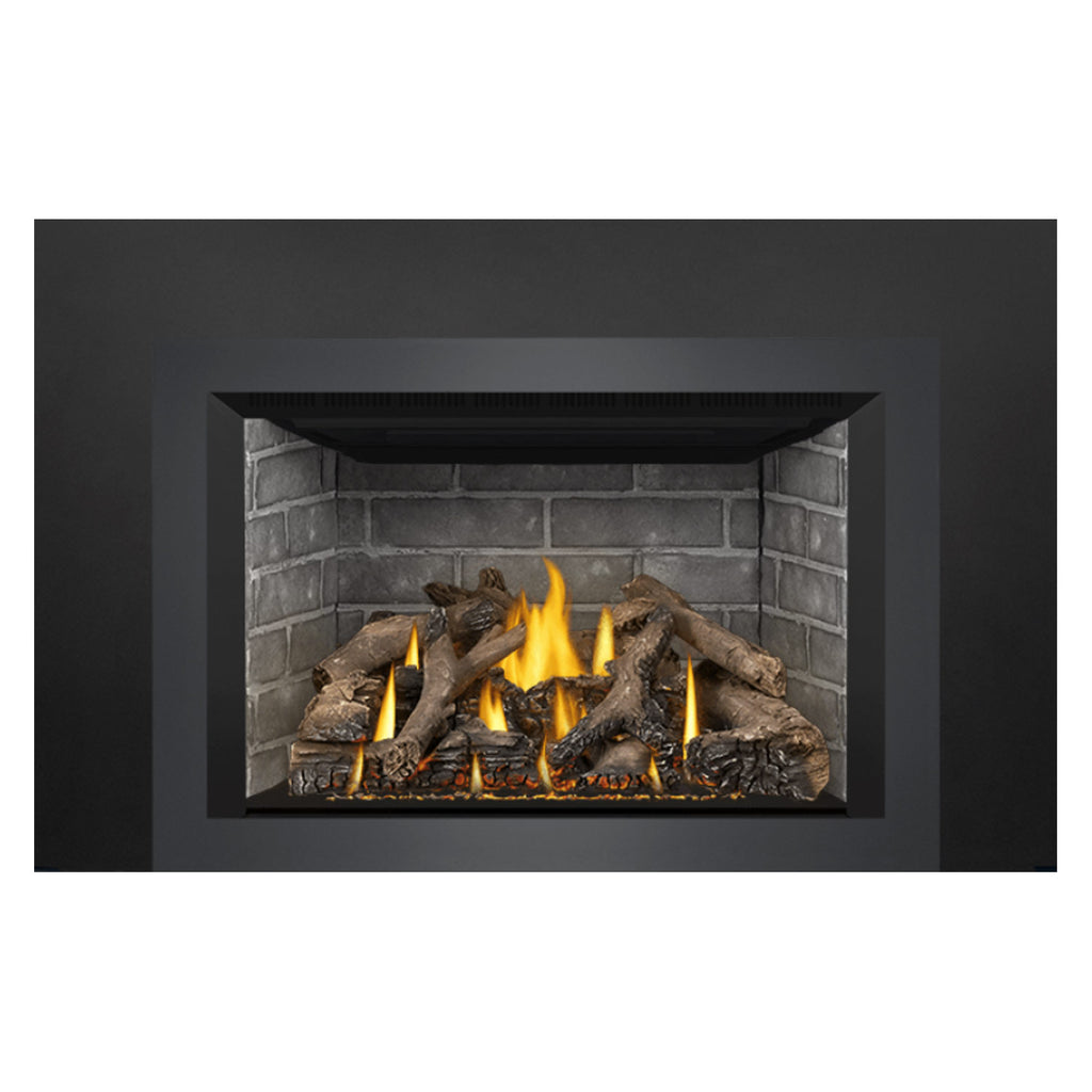 Gas fireplace insert view of brick interior with bright flames over dark logs