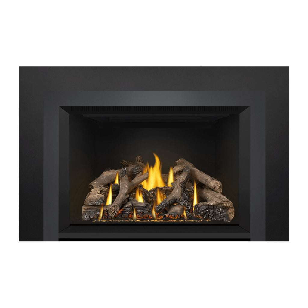 Direct vent gas fireplace insert with visible flame peaks above a gray log set.
