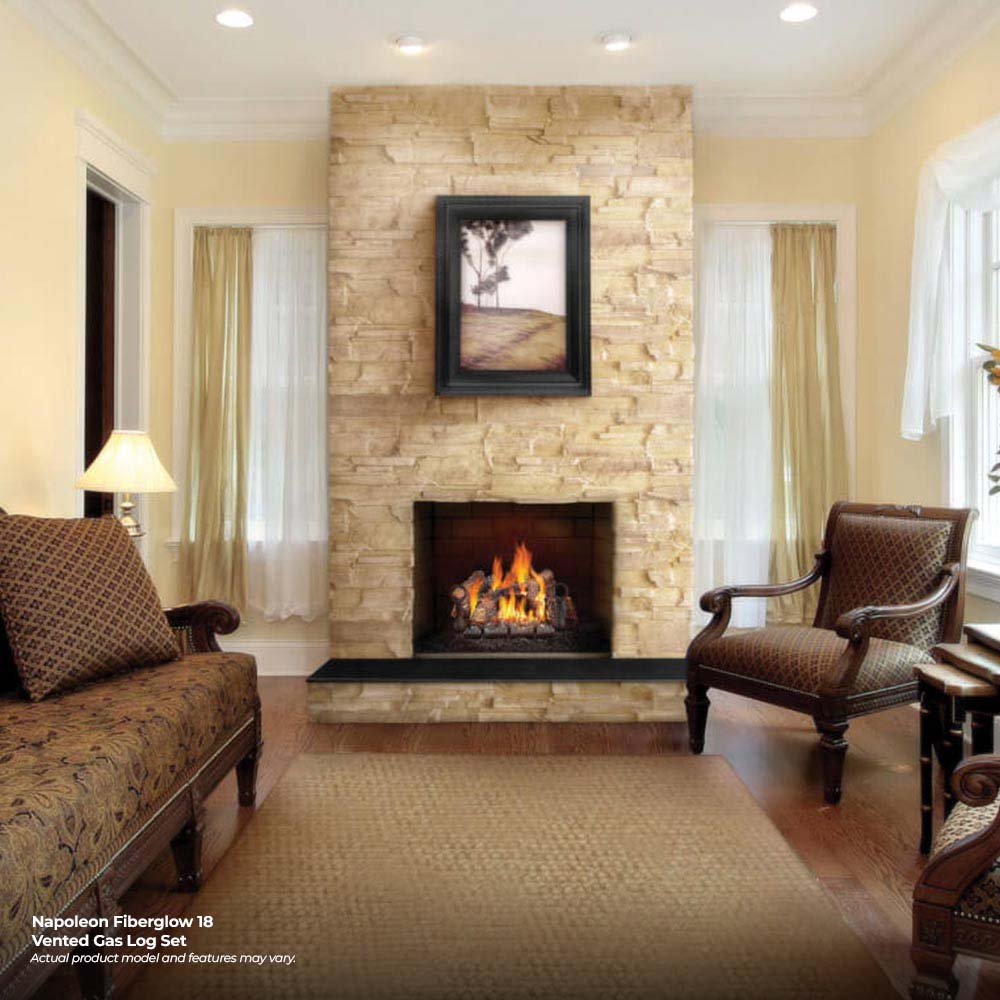 Vented gas log set with burning flames in a fireplace with stone surround