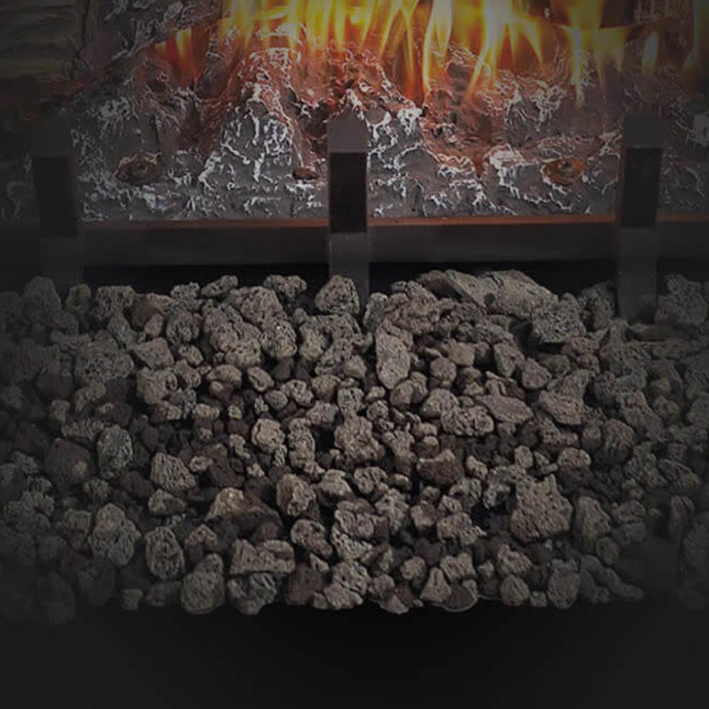 Vented gas log set with glowing flames behind a dark volcanic rock bed