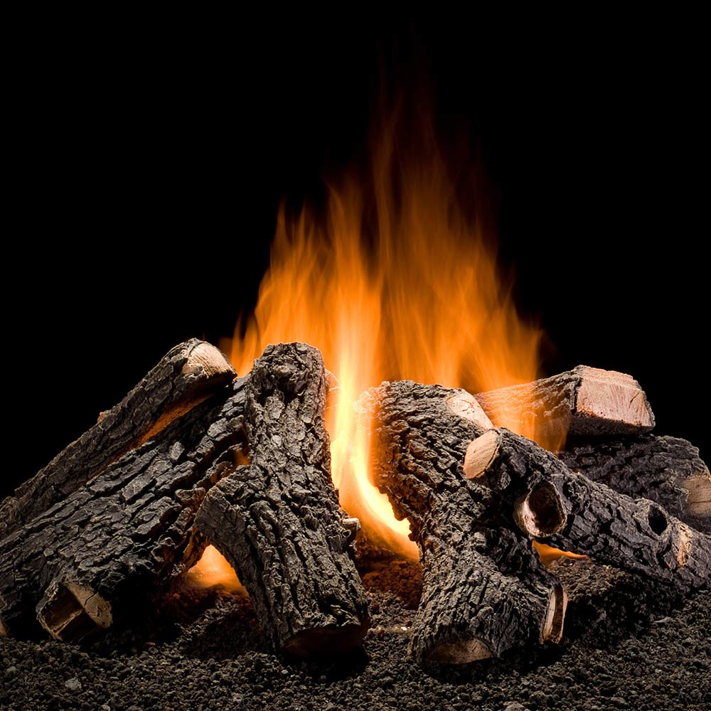 Outdoor gas logs with dark charred oak pieces and visible flames