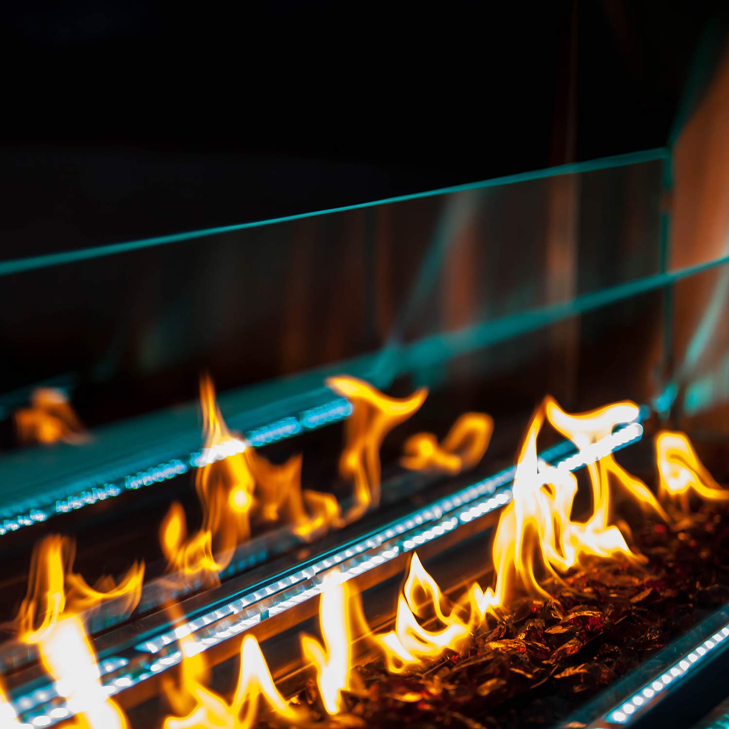 Linear outdoor fireplace with burning flames and blue LED lighting along the firebox