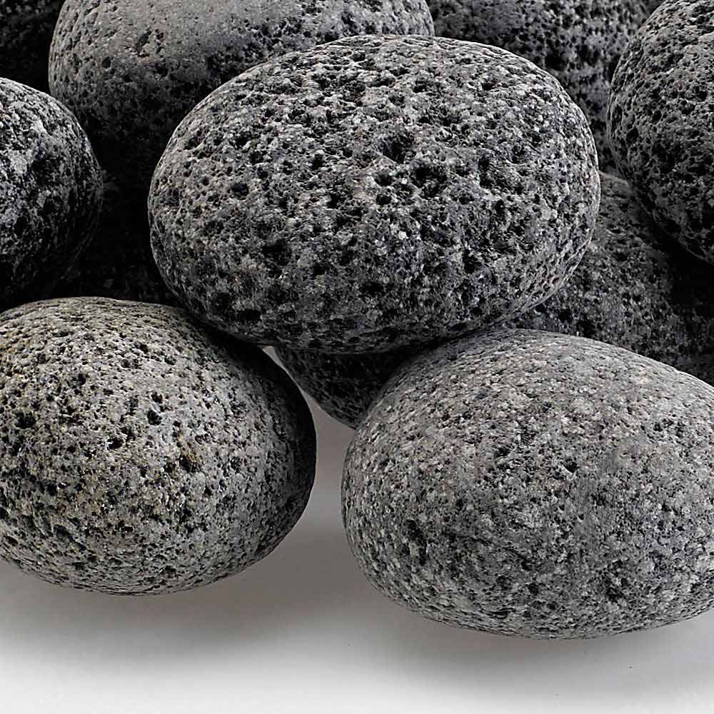 Gray lava stones close-up, porous textured surface on rounded rocks