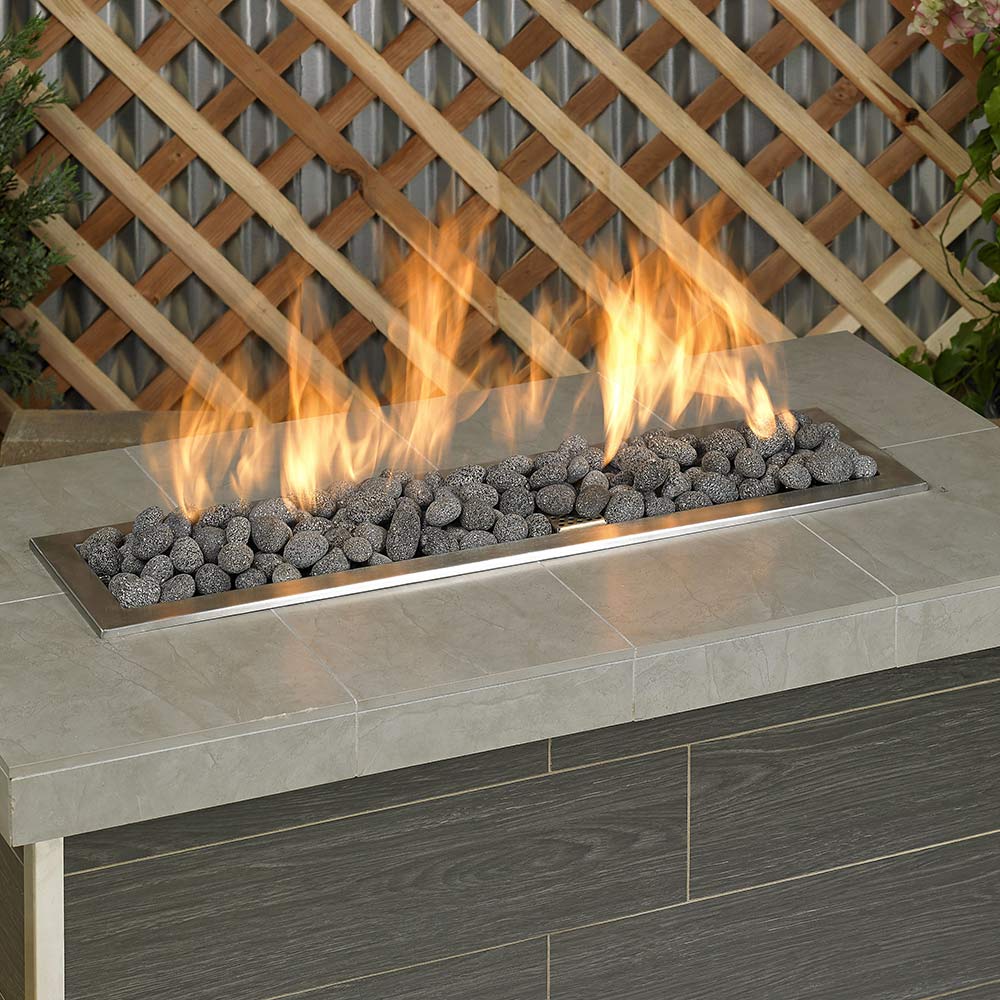 Gray lava stone fire glass in outdoor fire pit with visible flames