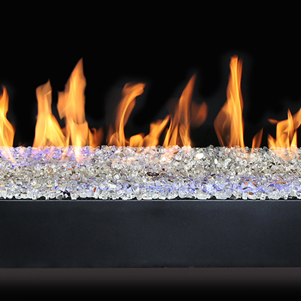 Linear gas burner with flames across a bed of clear glass rock