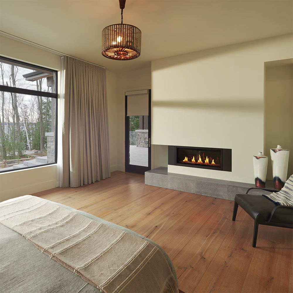 Recessed wall gas fireplace with glowing flames and log-style firebed in a dark trim