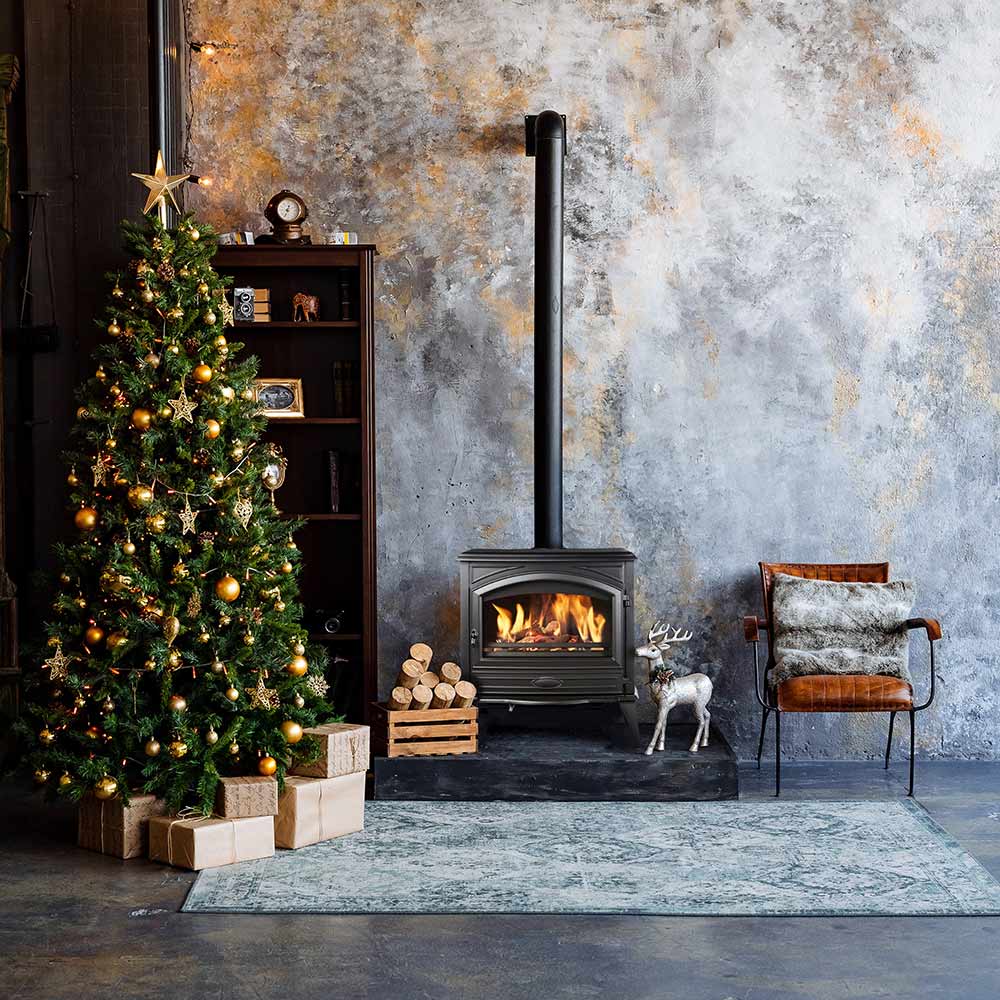 Freestanding wood stove with chimney pipe, burning firebox and stacked logs