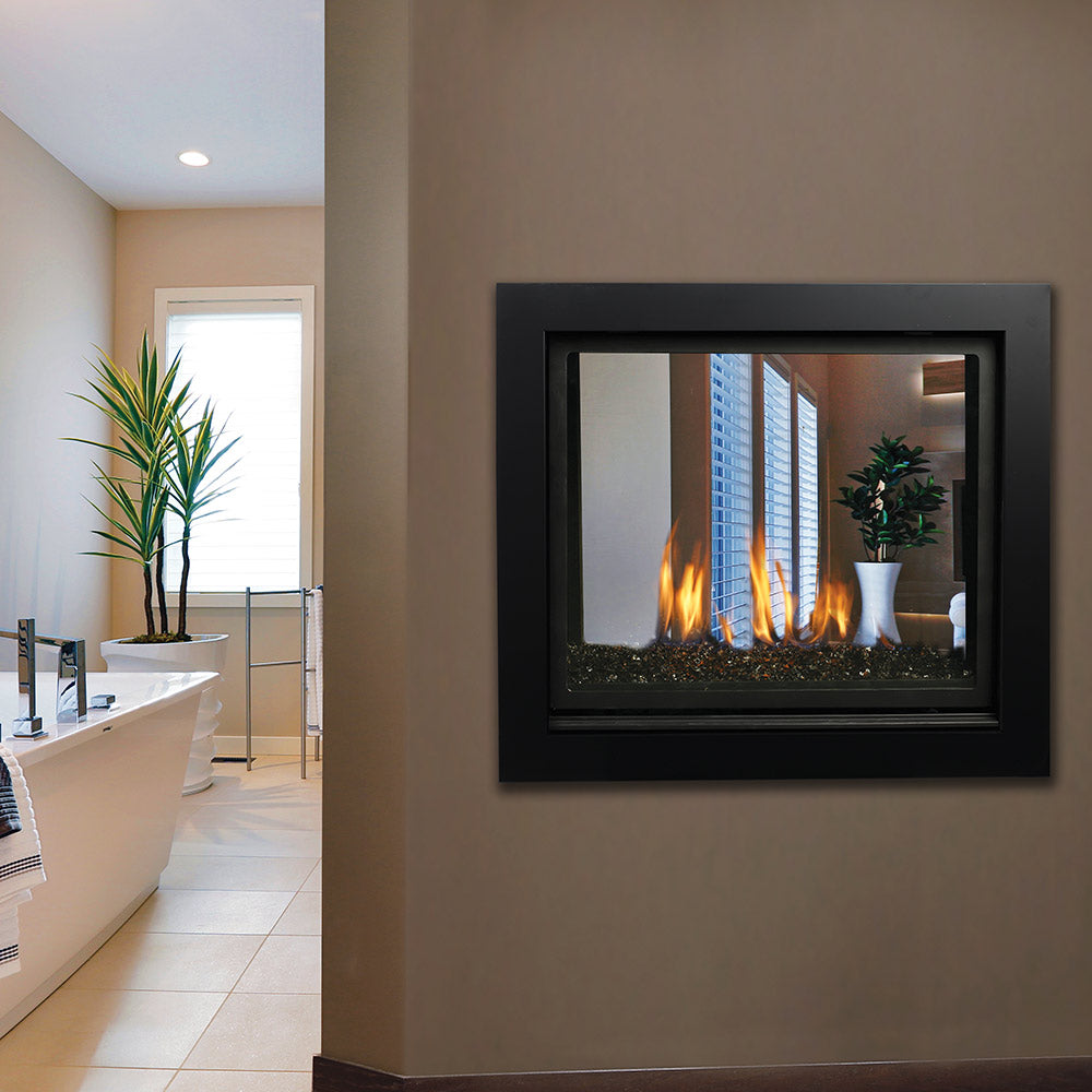 Gas fireplace with black frame and see-through window showing flames over a logbed