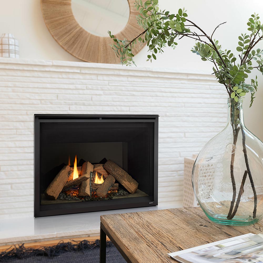Black-front direct vent gas fireplace with burning logs set in a brick interior