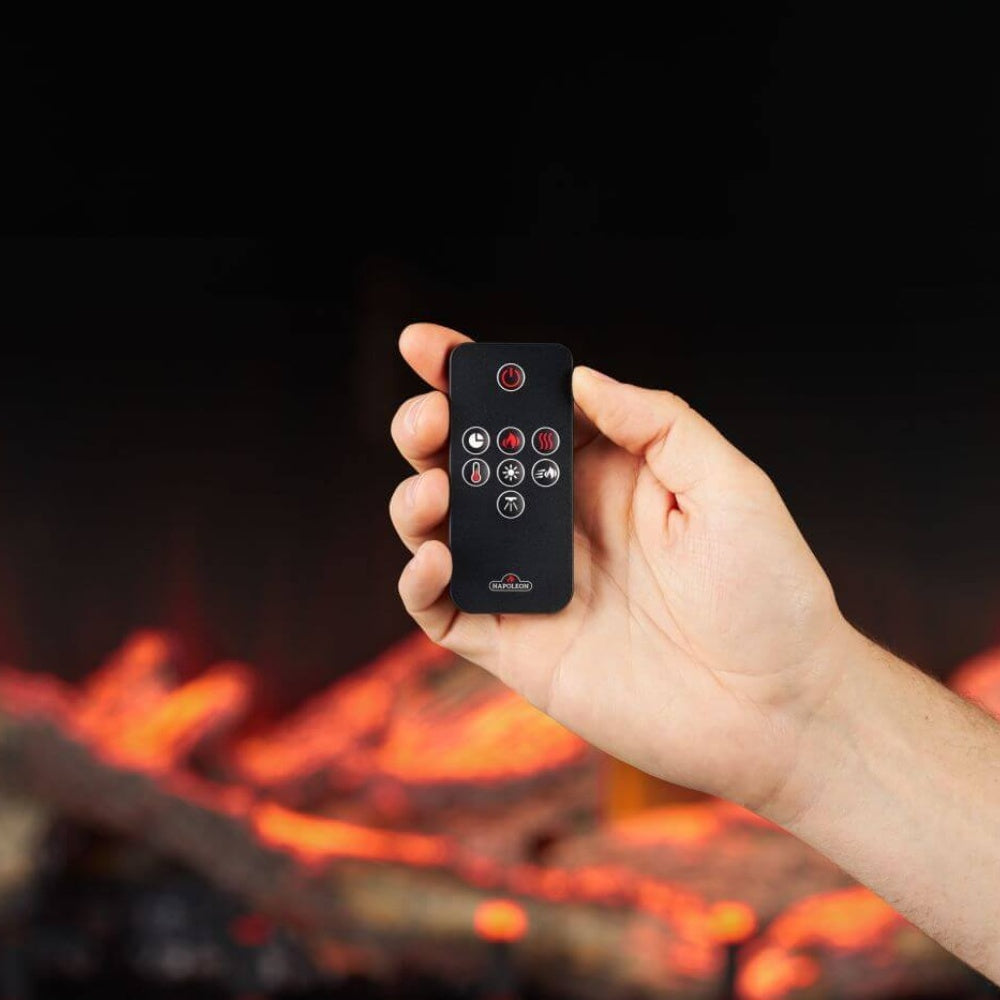Hand holding a black remote control for an electric fireplace