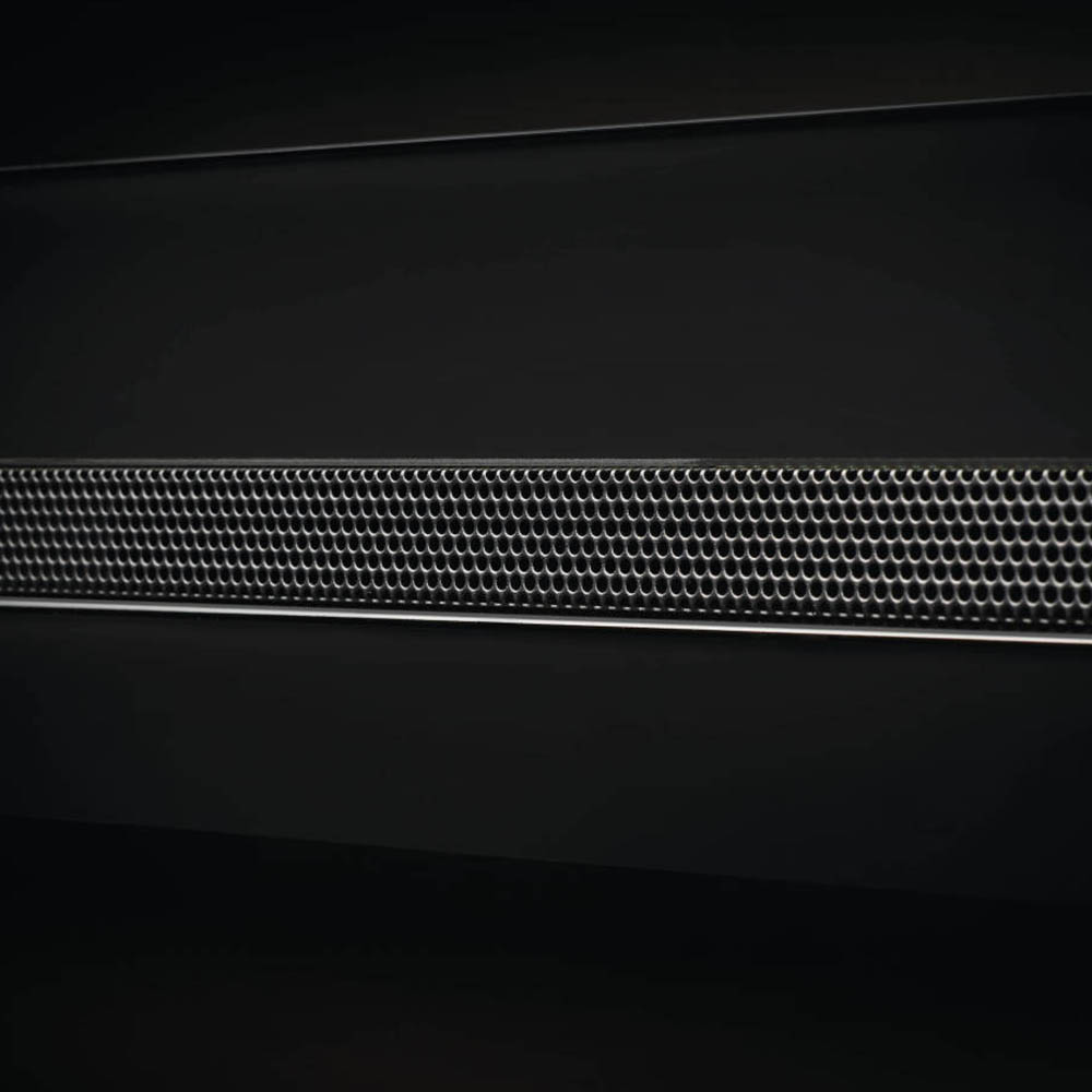 Black electric fireplace vent grille with a perforated metal mesh panel across the front.