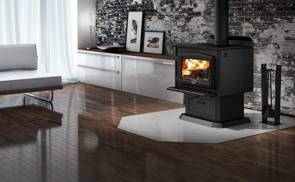 Black wood stove with glass door and burning logs with vertical stovepipe