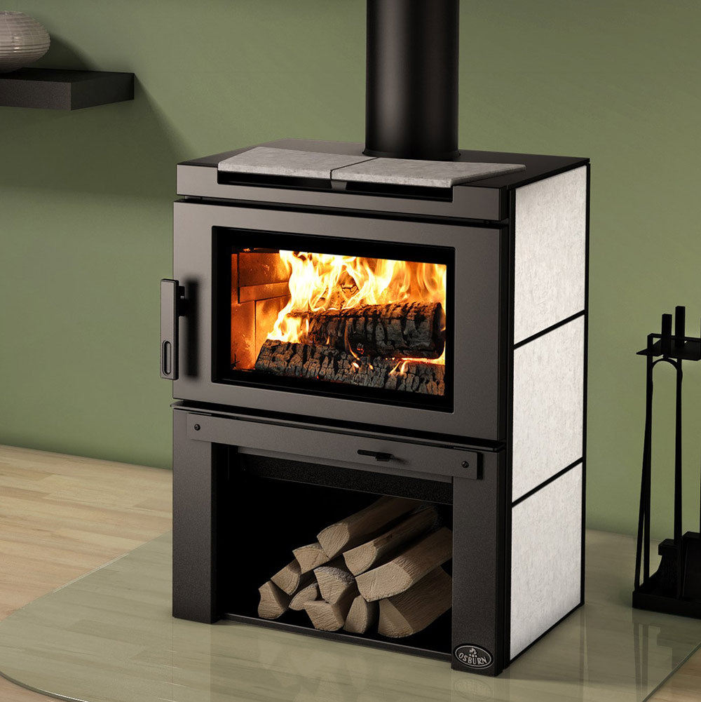 Wood stove with glass door, flames, and light stone side panels beside log storage