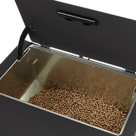 Black pellet stove hopper open with pellets in the tray