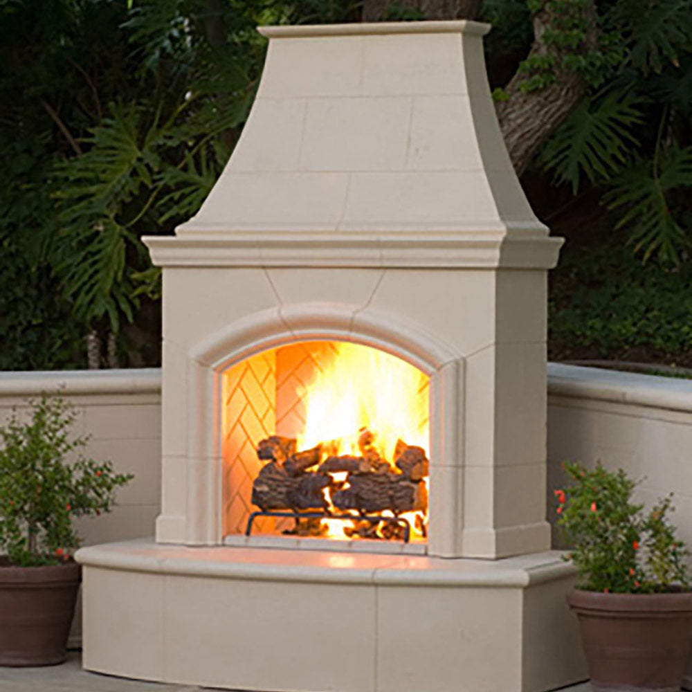 White outdoor gas fireplace with arched firebox glowing flames