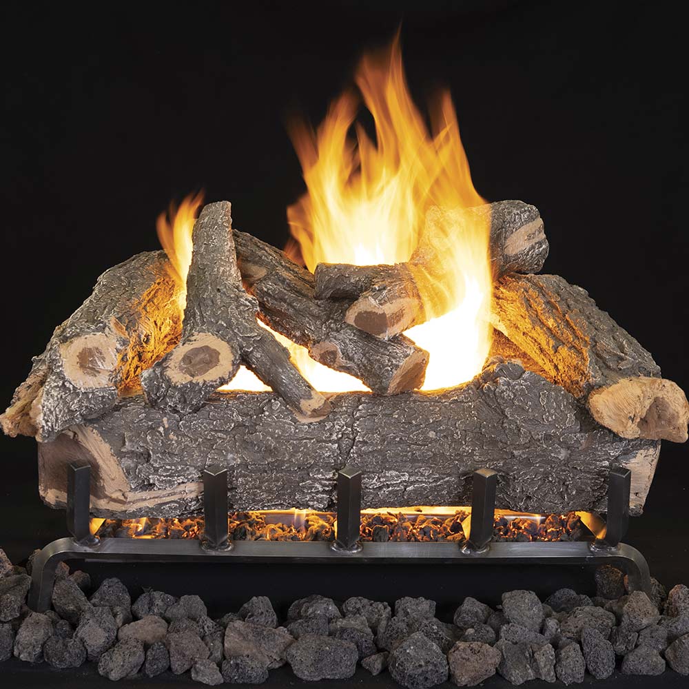Gas log set with weathered oak ceramic logs and glowing flame over dark lava rocks