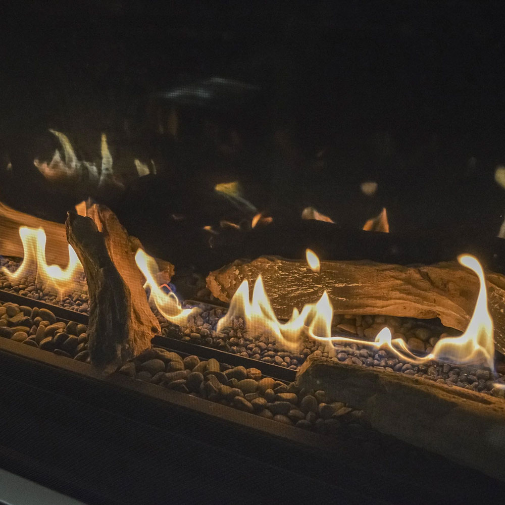 Angled view of glowing flames over fireglass in a linear gas fireplace